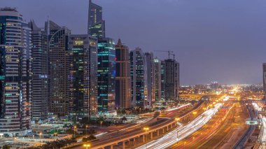 Dubai Marina ve Jlt gökdelenlerini, Dubai 'deki Şeyh Zayed yolunun hava görüntüsü gece gündüz geçiş zamanlarını çevreledi. Trafik ve metro hattı. Birleşik Arap Emirlikleri