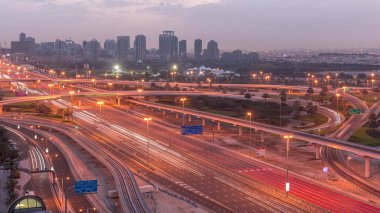 Dubai Marina 'dan Sheikh Zayed yoluna gece gündüz geçiş zamanı, Dubai. Trafik, kavşak ve yeşilliklerin olduğu bir bölge. Birleşik Arap Emirlikleri