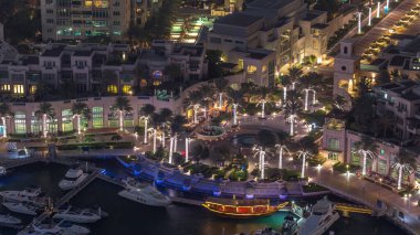 Dubai Marina'nın havadan üstten gündüz geceye geçiş saati. Dubai, Bae gün batımından sonra yüzen yatlar ve tekneler ile gezinti ve kanal. Işıklı binalar ve çeşme