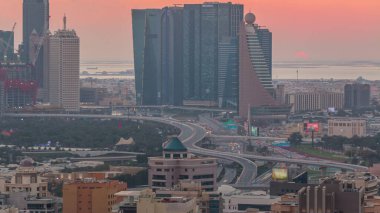 Günbatımı, Dubai, Dubai, Birleşik Arap Emirlikleri 'nden gelen yoğun trafiği olan gökdelenleri ve yolları ile modern şehrin üzerinde.