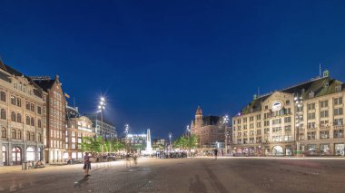 Panorama, Amsterdam 'daki Baraj Meydanı' nı gündüz gece geçiş zamanı Hollanda 'yı gösteriyor. Şehrin tarihi merkezidir ve Kraliyet Sarayı, kilise, müze ve otelleri de içerir.