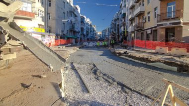 Beton, yol onarım inşaatı için bir moloz yığınında çalışıyor. Bir sürü işçi ve mikser makinası var. Tramvay raylarının yeniden inşası
