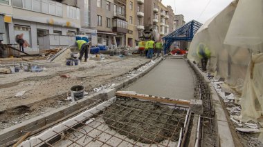 Çelik şebeke takviyesi yaptıktan sonra beton karıştırıcı hiperhızlandırıcı ile yolu açmak için hazır beton dökülüyor. Şehir caddesindeki tramvay raylarının yeniden inşası
