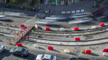 Onarım street timelapse üzerinde çalışır. Bir şehir sokak üzerinde yeni tramvay rayların döşenmesi. Yeni modern demiryolu rayları tramvaylar için montajı. Hava üstten görünüm. Tramvay parça kavşak üzerinde yeniden inşası