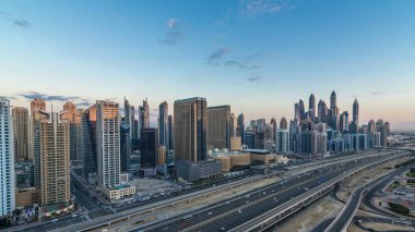 Dubai Yat Limanı gökdelenler hava üstten görünüm güneş doğmadan önce Jlt gelen Dubai gece gün timelapse, Birleşik Arap Emirlikleri için. Işıklı modern kuleleri ve Şeyh zayed yolu üzerinde trafik.