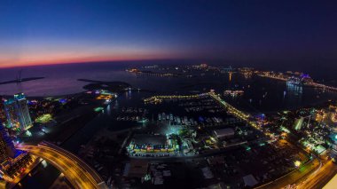 Dubai Marina Panorama 'dan gece gündüz hava görüntüsü. Gün batımından sonra ışığın Palm Jumeirah' a geçişi. Yat ve teknelerle yukarıdan manzara