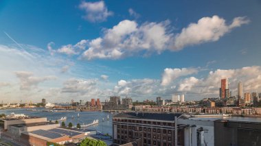 Arka planda Katendrecht ve Maas Nehri 'nin bulunduğu Maashaven üzerindeki hava zaman dilimi görüntüsü. Eski fabrika ofis ve etkinlik alanına dönüştü. Gökdelenlerin üzerinde dramatik bulutlu gökyüzü. Yollar boyunca trafik