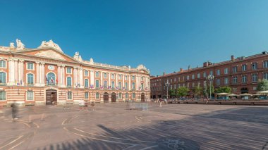 Capitole de Toulouse zaman çizelgesini gösteren panorama, Fransa 'nın Toulouse şehrinin tarihi belediye binası ve belediye kalbini, Capitole Meydanı' nda, çarpıcı mavi bulutlu gökyüzünün altında sergiliyor.