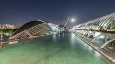 Valencia 'nın Sanat ve Bilim Şehri' nin, fütüristik mimari üzerine dolunay yansıması serin sulara yansıyan panoramik günden geceye geçiş zamanı. Büyüleyici bir İspanyol kültürel simgesi
