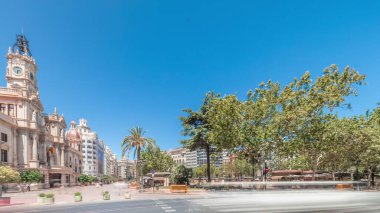 Panorama, Plaza de Ayuntamiento 'da Valencia Belediye Binası' nı (Ajuntament de Valencia) gösteriyor. Mavi gökyüzünün altında saat kulesi olan tarihi bir bina. İspanya 'nın ana meydanında gezinen insanlar