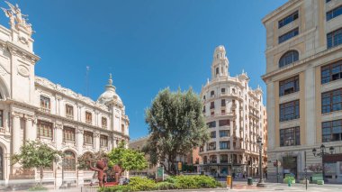 Belediye Binası Meydanı 'nda (Plaza del Ayuntamiento Meydanı) tarihi Posta Ofisi' ni (Palau de les Comunicacions) gösteren panorama. Süslü cephe, trafik ve İspanya şehir merkezinde mavi bir gökyüzü..