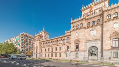 Panorama, İspanya, Valladolid Plaza de Zorrilla 'da Süvari Akademisi zaman çizelgesi gösteriyor. Karmaşık mimarisi olan tarihi askeri bina, mavi bulutlu gökyüzünün altında kalabalık şehir manzaralarıyla çevrili.