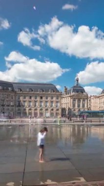 Place de la Bourse hyperlapse in Bordeaux, France, reflecting historic architecture. Tourists enjoy the landmark and the fountain. Timelapse of traffic and tram passing by.