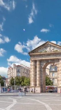 Fransa, Bordeaux 'da Place de la Victoire' da Porte dAquitaine kemeri ve dikilitaş. Tramvay hatları, kafeler ve mavi bulutlu gökyüzünün altında çevreleyen canlı Bordeaux 'nun tarihi simgesi.