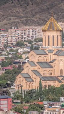 Tsminda Sameba Katedrali ya da Tiflis hava zaman çizelgesi Kutsal Üçlü Katedrali. Gürcistan 'ın Tiflis kentindeki Gürcistan Ortodoks Kilisesi' nin ana katedrali. Arka plandaki evler