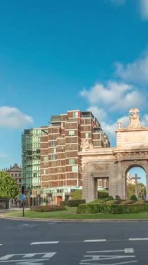 İspanya, Valencia 'da La Porta de la Mar zaman atlaması. Bir zamanlar ortaçağ duvarlarının bir parçası olan bu neoklasik kapı kalabalık bir kavşağın üzerinde duruyor. Gün batımında parlak bir gökyüzünün altında değerli bir şehir simgesi.