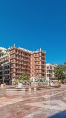 Valencias Plaza de la Virgen 'in zaman çizelgesini gösteren panorama, Katedral, Basilica de la Virgen de los Desamparados ve Turia Fountain' in mavi gökyüzü altında sergileniyor.