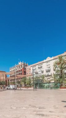 Panorama, İspanya, Valencia 'daki Plaza de la Reina' nın zaman çizelgesini gösteriyor. Tarihi bir kilise kulesi, hareketli kafeler ve sıcak Akdeniz mavi gökyüzünün altında merkezi bir çeşmesi olan canlı bir meydan..