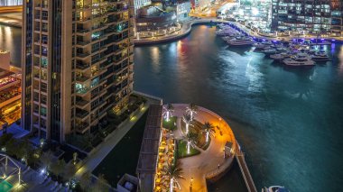 Dubai Yat Limanı içinde en yüksek gökdelenler gece timelapse, Glittering ışıklar ve akşam aydınlatma. Trafik yolda ve mesire avucunda