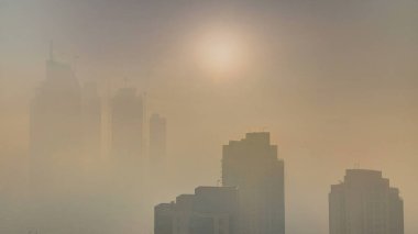 Sisli sabah gündoğumu Dubai timelapse şehir merkezinde. Şehir gökdelenler fütüristik görünümünü sis kaplı. Çatı modern kuleli havadan görünümden. Dubai, Birleşik Arap Emirlikleri
