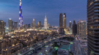 Dubai şehir merkezi silueti Burj Halife ve diğer gökdelenlerle birlikte, gün batımından sonra Dubai 'de, Birleşik Arap Emirlikleri' nin tepesinden panoramik manzara. Geleneksel ve modern binalar. Çevre yolunda trafik