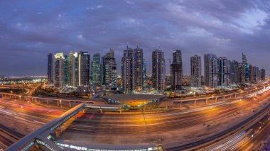 Dubai Limanı 'ndan Şeyh Zayed yoluna giden hava panoramik manzara. Dubai' deki Jlt aydınlatmalı gökdelenler, gece ve gündüz geçiş zamanı. Trafik, köprüler ve metro istasyonu. Birleşik Arap Emirlikleri