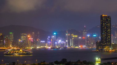 Hong Kong 'dan gece geçişi, Kowloon Körfezi' nden hava görüntüsü şehir merkezindeki zaman dilimi büyük gemi ve çatıdaki kuleler.