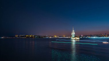 Maidens tower after sunset day to night transition timelapse in Istanbul, turkey, kiz kulesi tower. Panoramic city skyline on background with reflection on Bosforus water