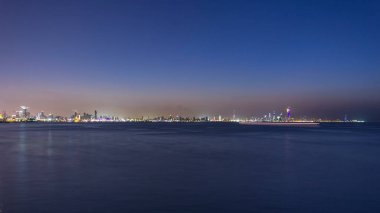 Kuveyt şehir merkezindeki gökdelenler ile gece gündüz geçiş zamanları alacakaranlıkta aydınlandı. Suyu yansıtan bir bilim merkezi görüntüsü. Kuveyt Şehri, Orta Doğu.