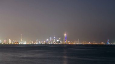 Kuveyt şehir merkezindeki gökdelenler ile gece gündüz geçiş zamanları alacakaranlıkta aydınlandı. Suyu yansıtan bir bilim merkezi görüntüsü. Kuveyt Şehri, Orta Doğu.