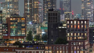 Rotterdam, Hollanda 'daki Katendrecht yarımadası ve Maashaven limanının hava ve gece geçiş zamanı. Günbatımından sonra parlayan pencereleri olan modern gökdelenler.