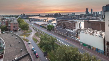 Gün batımında Maashaven zamanının hava panoramik görüntüsü Rotterdam 'da demirli iç gemilerle, Katendrecht ve Maas Nehri. Eski fabrika ofis ve etkinlik alanına dönüştü. Yollar boyunca trafik
