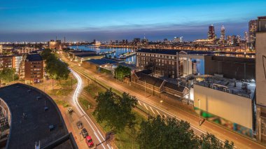 Rotterdam 'daki Katendrecht ve Maas Nehri gibi demirli gemilerle Maashaven' daki hava panoramik görüntüsü günden geceye geçiş zamanı. Eski fabrika yakınlarındaki trafik ofis ve etkinlik alanına dönüştü