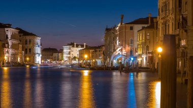 Grand canal with gondolas near Rialto Market day to night transition timelapse after sunset, San Polo, Venice, Italy viewed from pier at summer