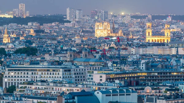 Paris 'teki evlerin çatılarının üstündeki hava panoraması gece gündüz geçiş zamanı. Notre Dame de Paris 'in akşam manzarası ve Saint-Sulpice gün batımından sonra aydınlandı.