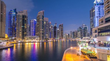 Dubai Marina rıhtımı, Dubai 'deki köprüden gece vardiyasına kadar uzanan kuleleri ve yatları olan Birleşik Arap Emirlikleri. Yapay kanalları ve gökdelenleri olan bir bölge.