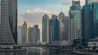 Dubai Marina Kanalı 'nın sabah manzarası, modern kuleleri ve yatlarıyla Dubai' deki köprüden yansıyan güneş doğumu saati, Birleşik Arap Emirlikleri.
