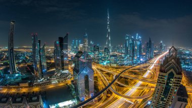 Modern gökdelenler ve Dubai şehir merkezindeki lüks otobanlar gecesi. Kule çatısından üst hava manzarası. Yol kavşağı trafiği. Fisheye lensleri. Dubai, Birleşik Arap Emirlikleri