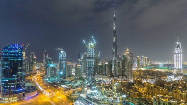 Dubai Şehir Merkezi 'nden geceye geçiş panoramik zaman dilimi. Geceleri büyük, fütüristik şehir üzerinde hava manzarası. Dubai 'nin gökdelenleri, Birleşik Arap Emirlikleri. Akşam gökyüzü çatıdan yükseliyor