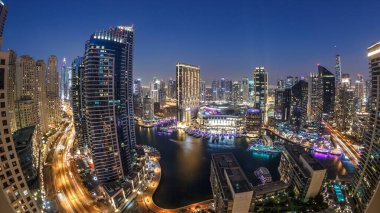 Dubai Marina 'nın gece gündüz aydınlanması. Hava geçiş panoramik zaman dilimi, BAE. Modern gökdelenler ve konut binaları. Yapay kanal şehrindeki alışveriş merkezinin yakınındaki yatlar ve tekneler.