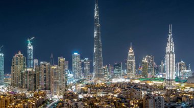 Dubai Şehir Merkezi 'nin ufuk çizgisi gece gündüz Burj Halife ve diğer panoramik manzaralı Dubai, Birleşik Arap Emirlikleri. Geleneksel ve modern binalar. Çember yollarda ve çeşmelerde trafik