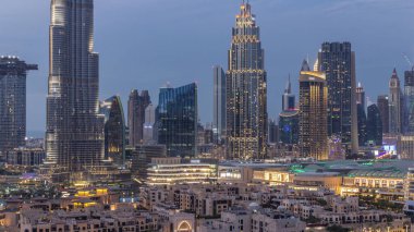 Dubai Şehir Merkezi 'nin ufuk çizgisi gün batımından gece saatlerine kadar Dubai, Birleşik Arap Emirlikleri' nin tepesinden panoramik manzaralı kulelerle dolu. Güneş gökdelenden yansıyor. Çember yollarda ve çeşmelerde trafik