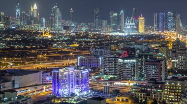 Şehir merkezinde büyük gökdelenler ve onlardan gelen ışıklar ve renkli gökyüzü, Dubai, Birleşik Arap Emirlikleri ile finans bölgesi Timelapse 'nin havadan görünüşü