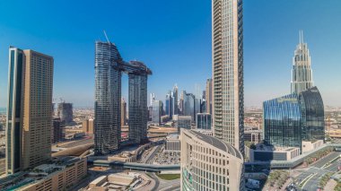 Yeni kulelerin ve yoğun yolları olan yüksek binaların havadan görünüşü tüm gün boyunca uzun gölgelerle Dubai şehir merkezinden hızla ilerlerken otoyol, Dubai, Birleşik Arap Emirlikleri 'nde trafik vardı.