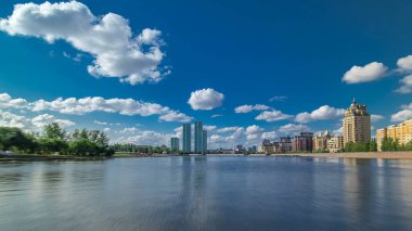 Astana, Kazakistan. Keyif teknesinden Astana 'da Ishim nehrinde hareketli bir seyahat görüntüsü. Mavi gökyüzü ve bulutlarla dolu bir yaz gününde. Bulanık hareket