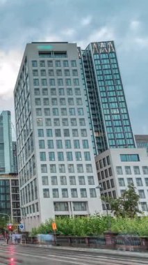 Frankfurts Innenstadt bölgesindeki cam gökdelenlere bakıyorum. Modern mimari gökyüzünde yağmurlu bulutları yansıtır. Yol ayrımında trafik vardı. Almanya.