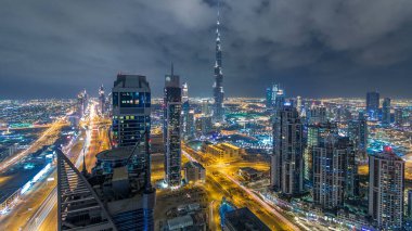 Dubai 'nin panoramik silueti günden geceye geçiş zamanı, Birleşik Arap Emirlikleri. Ünlü gökdelenler kule çatısı manzaralı. Güzel bulutlu gökyüzü. Renkli seyahat ve iş geçmişi