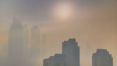 Sisli sabah gündoğumu Dubai timelapse şehir merkezinde. Şehir gökdelenler fütüristik görünümünü sis kaplı. Çatı modern kuleli havadan görünümden. Dubai, Birleşik Arap Emirlikleri