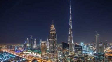 Dubai şehir merkezindeki Panorama 'dan gece, gündüz en yüksek binayla ve Şeyh Zayed karayolu trafiğiyle geçiş zamanı. Günbatımından sonra modern kulelerle gökdelenin çatısından gökyüzü manzarası
