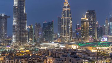 Dubai Şehir Merkezi 'nin ufuk çizgisi gün batımından gece saatlerine kadar Dubai, Birleşik Arap Emirlikleri' nin tepesinden panoramik manzaralı kulelerle dolu. Güneş gökdelenden yansıyor. Çember yollarda ve çeşmelerde trafik